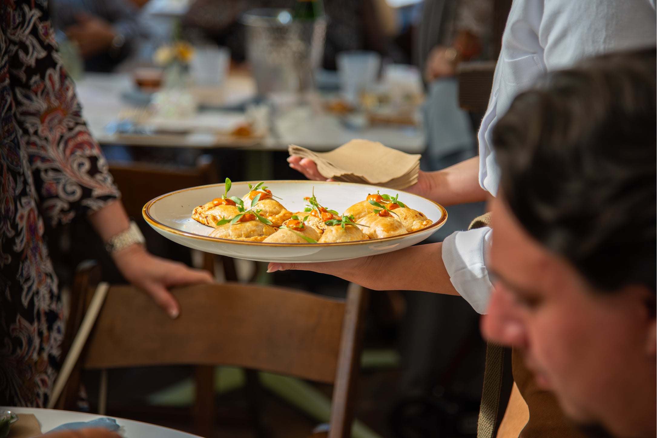 Person holding a plate of food in a restaurant setting
