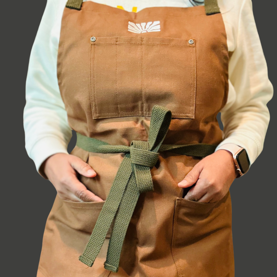 Tough enough for daily restaurant life, our SFC Apron combines sturdy 12 oz. Duck Canvas fabric with a chic design. Made in USA with California brown fabric and dusty olive green straps. 32"x31" body, 39" waist straps, and adjustable neck strap. Easy to clean with machine wash and low tumble dry. (Cook like a pro with this stylish apron, made for the rigors of restaurant life.)
