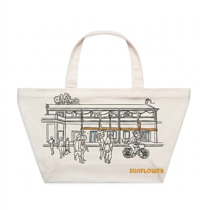 Tote bag with a printed design of a building and people, featuring the brand 'Sunflower'.