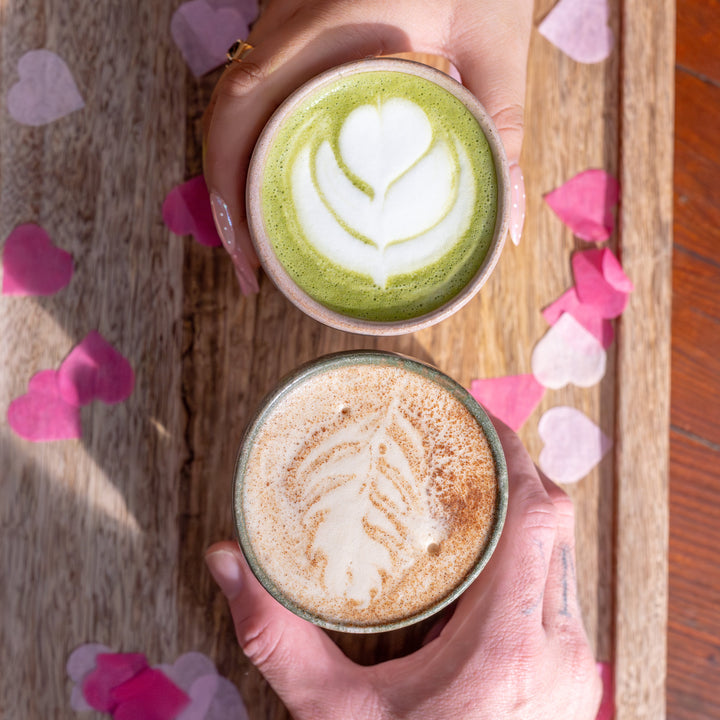 two hands holding coffee drinks
