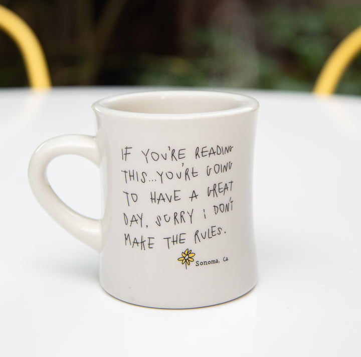 White coffee mug with the text "if you're reading this...you're going to have a great day, sorry I don't make the rules"